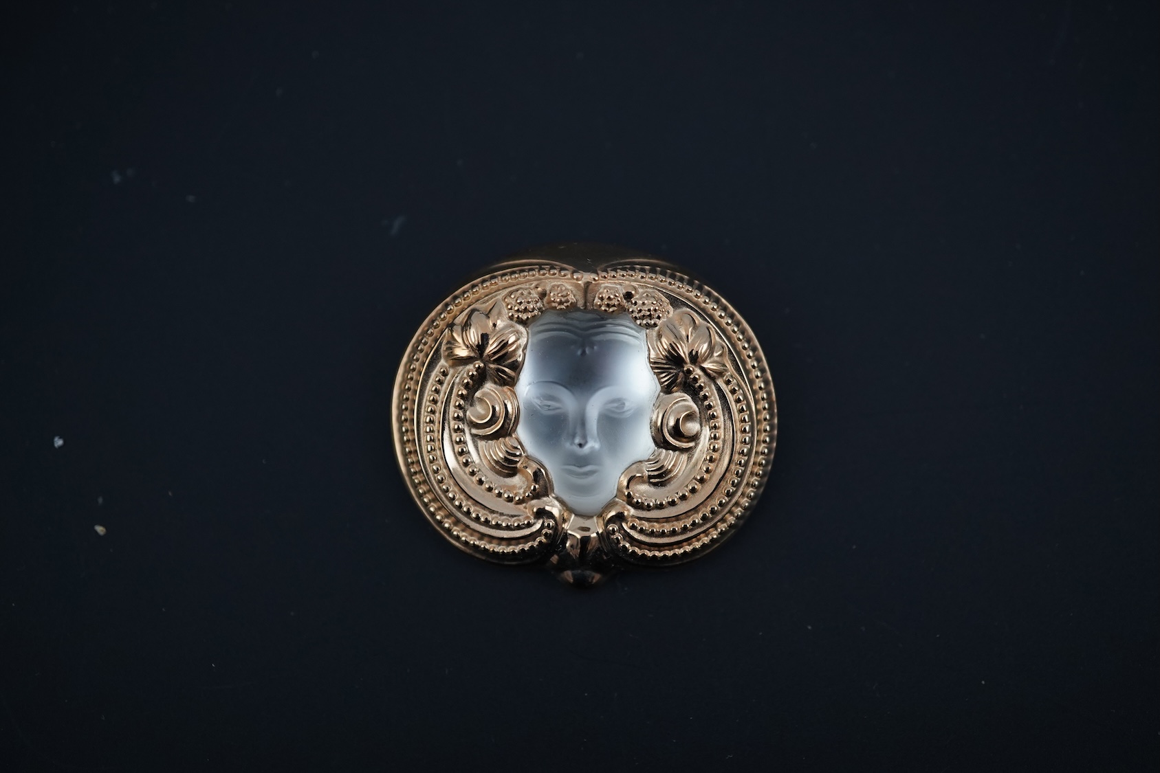 A Lalique mask brooch, cased